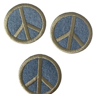 May include: Three denim peace sign patches with a beige outline. The patches are circular and have a textured denim fabric.