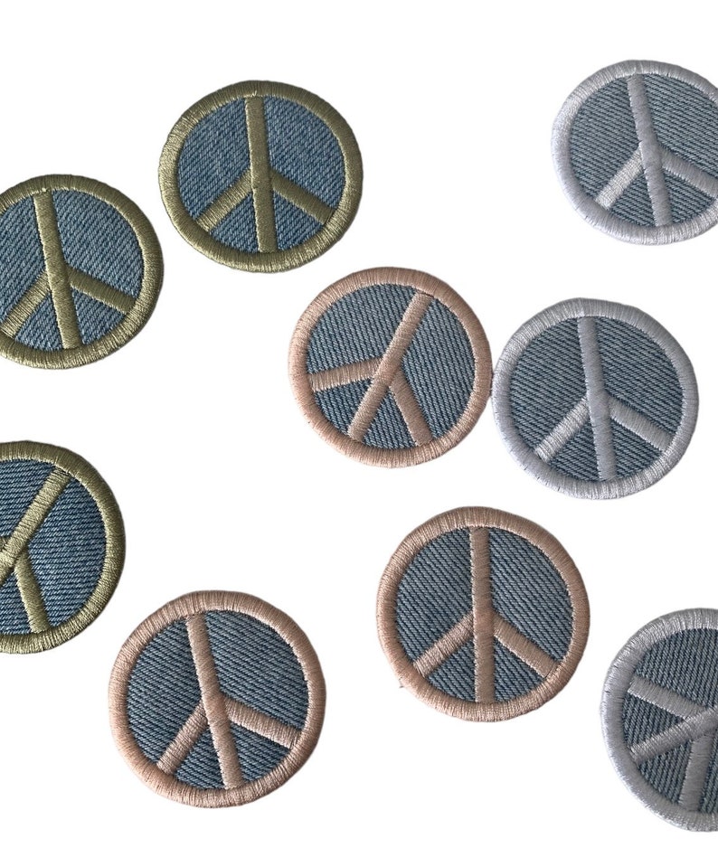 May include: Nine embroidered peace sign patches in various colors. The patches are circular and feature a peace sign design with a denim background.
