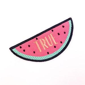 May include: Embroidered watermelon patch with pink flesh, black seeds, and a teal rind. The word "TRUE" is embroidered in tan thread across the center. The patch has a black border and is set against a white background.