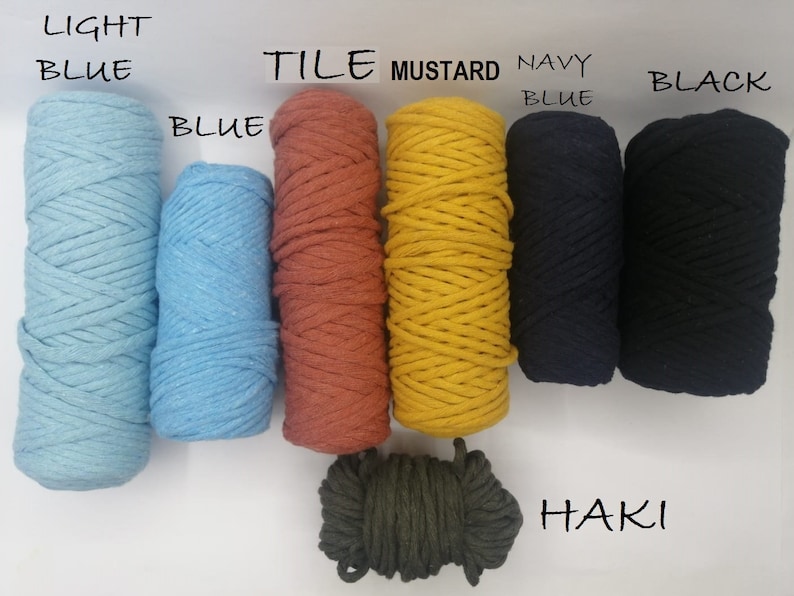 May include: A collection of colorful macrame cord spools in various shades. Colors include light blue, blue, tile, mustard, navy blue, black, and khaki. Text labels identify each color. The spools are tightly wound and ready for crafting.