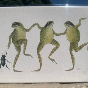 May include: A watercolour illustration of three green frogs dancing. The frogs are in a line, with the frog on the left holding the hand of the frog in the middle, and the frog in the middle holding the hand of the frog on the right. The frogs are all facing forward, and their legs are in a dancing position. There is a small black beetle in the bottom left corner of the image.