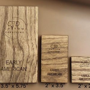 Op de afbeelding: Drie houten borden met de tekst "CJD Custom Creations" en "Early American" in een cirkel. De borden zijn 3,5 inch bij 5,75 inch, 2 inch bij 3,5 inch en 2 inch bij 2 inch.