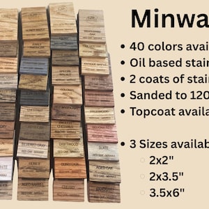 A collection of stained wood sample swatches arranged in a fan layout, each labeled with the stain color and wood type. Swatches include shades like Sedona, Cherry, Dark Walnut, Ebony, Slate, Red Mahogany, and Golden Oak, all engraved with the "CJD Custom Creations" logo. These samples show how different Minwax stains appear on Red Oak wood, helping customers choose the right finish for their woodworking or home improvement projects.