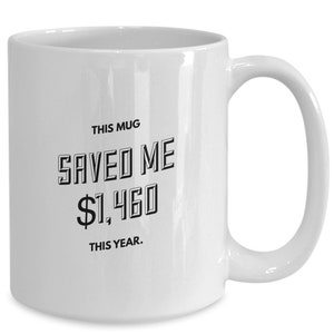 May include: White ceramic mug with black text that reads "This mug saved me $1,460 this year."