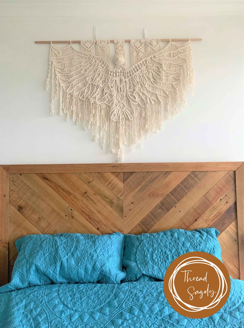 Large macrame bird wall hanging sits above a queen bed with a wooden headboard. The Eagle is over 1 metre wide and 1 metre long at its longest point.