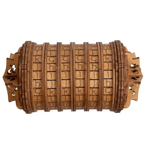 Può includere: Una scatola di puzzle in legno con una serie di cilindri rotanti, ognuno con lettere dell'alfabeto incise. La scatola è chiusa e sembra essere in legno scuro.