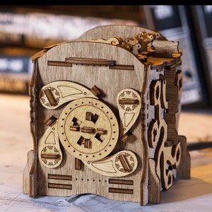 Könnte beinhalten: Eine Holzkästchen-Rätselbox mit komplizierten Details und einem drehbaren Zahnradmechanismus. Die Box ist aus hellbraunem Holz gefertigt und hat eine natürliche Oberfläche.