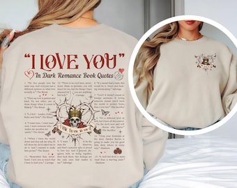 Peut inclure: Sweat-shirt beige avec l'inscription rouge "I LOVE YOU" et "In Dark Romance Book Quotes" en dessous. Le dos présente un crâne couronné, des épines et des citations. Une version plus petite du motif est sur le devant.