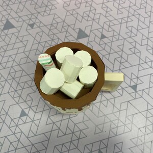 This image shows the top of the hot cocoa mug to better show the marshmallows and the stir stick inside the mug