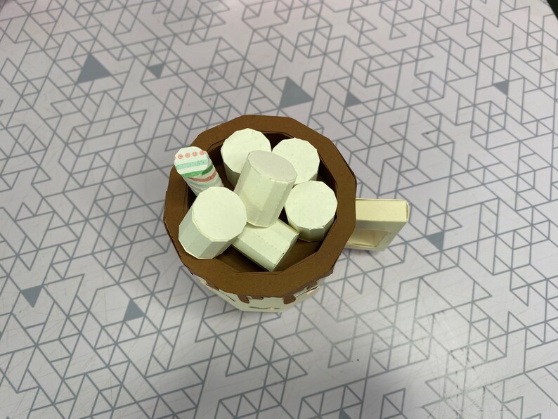 This image shows the top of the hot cocoa mug to better show the marshmallows and the stir stick inside the mug