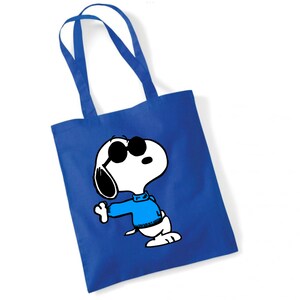 K&ouml;nnte beinhalten: Eine blaue Tragetasche mit einer wei&szlig;en Umrandung von Snoopy, der eine Sonnenbrille und einen blauen Pullover tr&auml;gt.