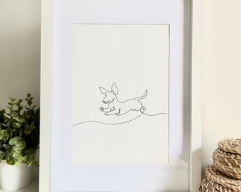 May include: A framed minimalist line art print of a dachshund dog in mid-jump. The black line drawing is set against a white background, within a white frame. A simple, modern artwork suitable for home decor, with a clean aesthetic.