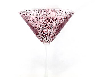 Una copa de cóctel/martini con lunares rosas