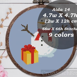May include: Aida 14 count cross stitch pattern of a snowman holding a gift. The pattern is 4.7 inches wide by 4.7 inches high, or 12 cm wide by 12 cm high. It uses 9 colors and requires 66 stitches wide by 66 stitches high.