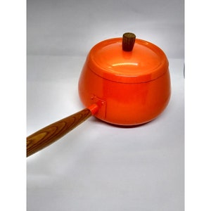 May include: Orange enamel saucepan with a wooden handle and lid. The lid has a wooden knob.