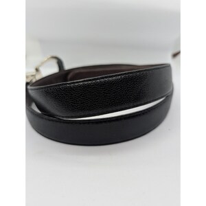 May include: A white ceramic mug with a black handle and the text "But First, Coffee" in a bold, black font. The mug is sitting on a wooden surface. The mug is approximately 4 inches tall.