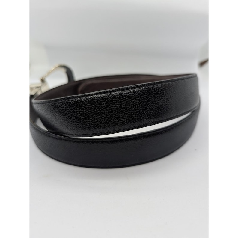 May include: A white ceramic mug with a black handle and the text "But First, Coffee" in a bold, black font. The mug is sitting on a wooden surface. The mug is approximately 4 inches tall.