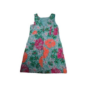 May include: A sleeveless dress with a V-neckline, featuring a vibrant floral pattern. The dress showcases large flowers in shades of pink and orange, set against a light blue background with green foliage. The dress is a knee-length style.