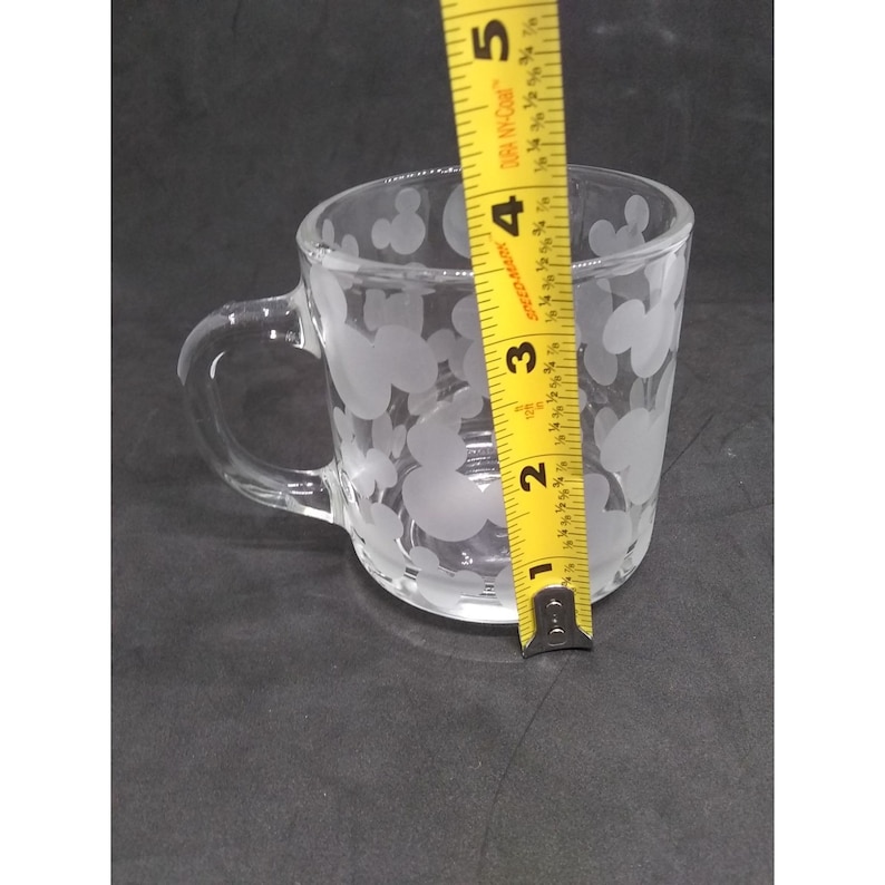 Peut inclure: Une tasse en verre transparent avec un motif givr&eacute; de t&ecirc;tes de Mickey Mouse. La tasse mesure environ 9 cm de haut.