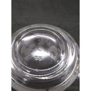 Peut inclure: Pichet en verre transparent avec un fond rond et une petite marque carr&eacute;e avec les lettres "SS" et le num&eacute;ro "43" au fond.