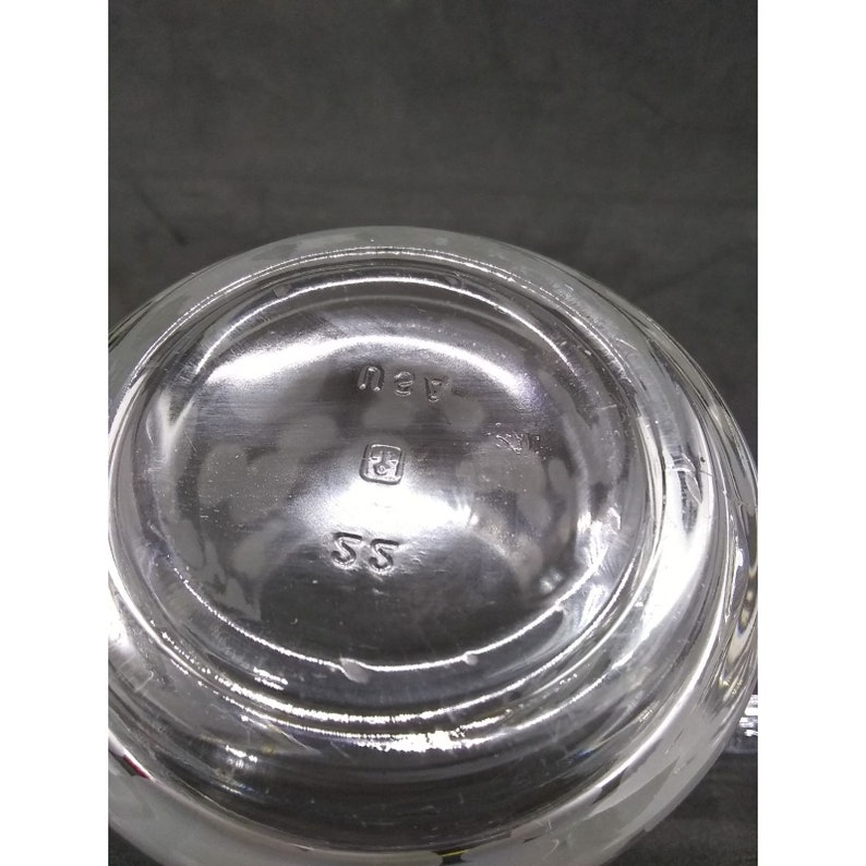 Peut inclure: Pichet en verre transparent avec un fond rond et une petite marque carr&eacute;e avec les lettres "SS" et le num&eacute;ro "43" au fond.