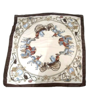 May include: A square white silk scarf with a brown border. The scarf features a repeating pattern of horse-drawn carriages, horses, and chains. The pattern is in shades of blue, red, brown, and white.