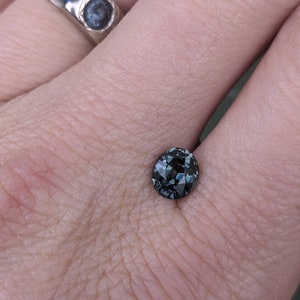May include: A dark blue gemstone with a faceted cut, set in a ring.