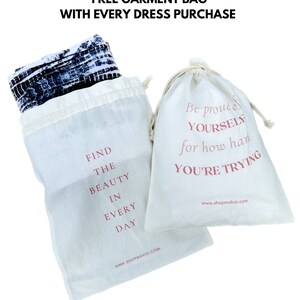 May include: Two white cotton drawstring bags with pink text. One bag says "Find the beauty in every day" and the other says "Be proud of yourself for how hard you're trying". Both bags have the website "www.shopmahisi.com" printed on them.