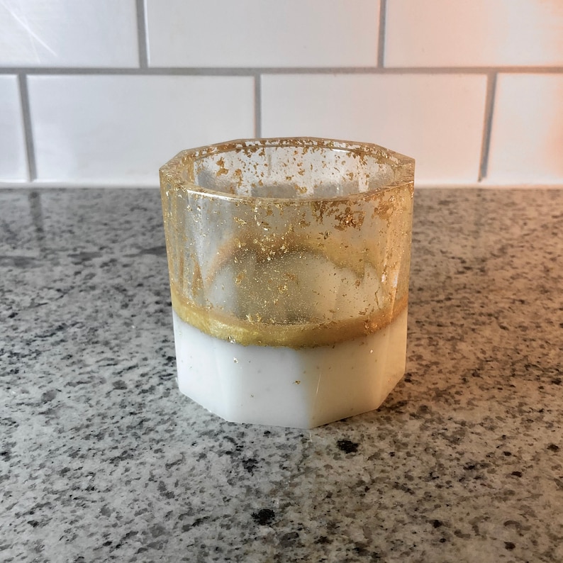May include: A white hexagonal resin cup with a gold glitter layer and a gold rim.