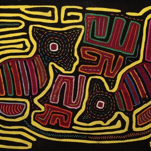 Pode incluir: Uma obra de arte têxtil com duas figuras de animais estilizadas em vermelho, azul e verde, delineadas em amarelo sobre um fundo preto. O design inclui padrões intrincados e detalhes costurados, mostrando uma composição vibrante e detalhada.