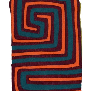 Könnte beinhalten: Rechteckiger Stoff mit geometrischem Design. Das Muster zeigt türkisfarbene, orangefarbene und burgunderfarbene Linien, die ein labyrinthartiges Design bilden. Der Stoff hat eine abgerundete Oberseite und einen einfarbigen orangefarbenen Boden.