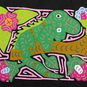 Groene leguaan Mola, gevlekte hagedis die tussen roze en rozenbloesems klimt, handgestikt San Blas-doek, Kuna inheemse Panamese volkskunst