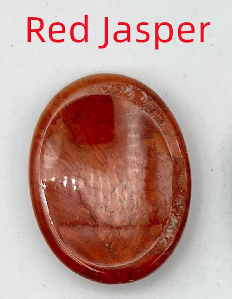 K&ouml;nnte beinhalten: Roter Jaspis-Handstein mit einer glatten, polierten Oberfl&auml;che und einem wirbelnden rot-wei&szlig;en Muster.