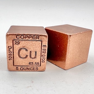 May include: Two copper cubes, one with the periodic table element for copper, labeled "Copper, Cu, 29, 63.55, 1085°C, 8.92 g/cc, 5 ounces".