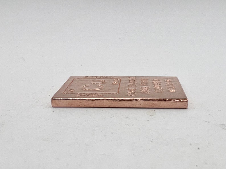 以下が含まれることがあります： 化学記号「Cu」と「One Ounce Fine Copper 99.9% Pure」という刻印が施された銅の棒です。