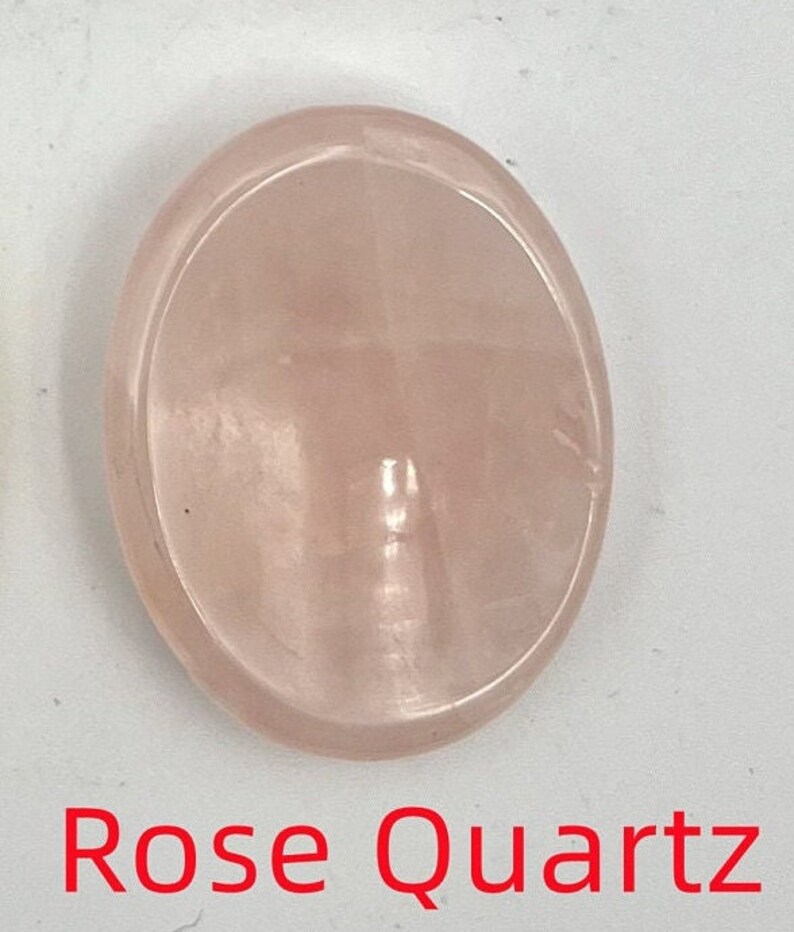 K&ouml;nnte beinhalten: Ein glatter, ovaler, blassrosa Rosenquarz-Edelstein.