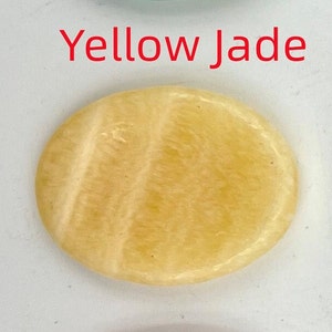 K&ouml;nnte beinhalten: Ein glatter, ovaler gelber Jadestein mit hellgelber Farbe und wei&szlig;en Streifen.