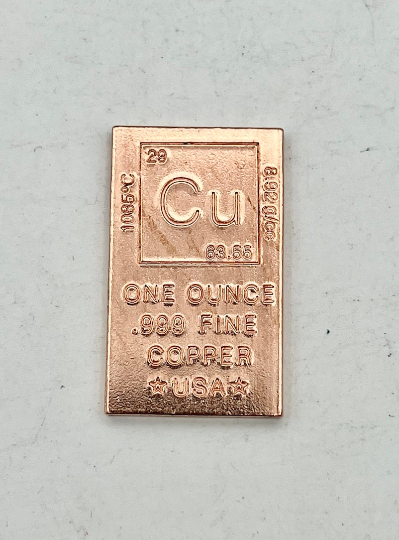 以下が含まれることがあります： 銅の化学記号Cuと「ONE OUNCE .999 FINE COPPER USA」の文字が刻まれた銅の棒