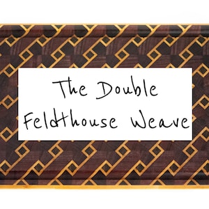 May include: Rectangular wooden chopping board with a geometric pattern in shades of brown and gold. The text "The Double Feldthouse Weave" is written in black on a white rectangle in the centre of the board.