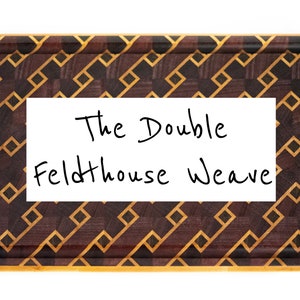 May include: A rectangular wooden cutting board with a brown and yellow geometric pattern. The text "The Double Feldthouse Weave" is written on a white label attached to the board.