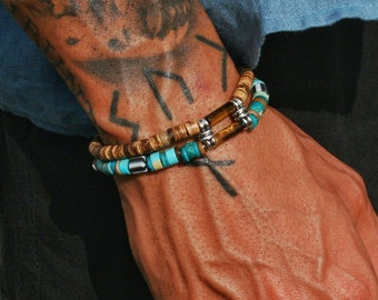 May include: Two bracelets on a person's wrist. The bracelets are made of wood and turquoise beads with silver accents.