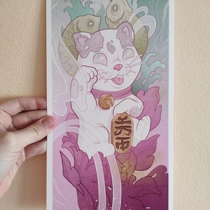 May include: A white Maneki-Neko, or lucky cat, with a pink collar and a gold bell, is depicted in a Japanese-style illustration. The cat is holding a gold coin with the Japanese character for "fortune" written on it. The background features swirling clouds, waves, and pink flowers.