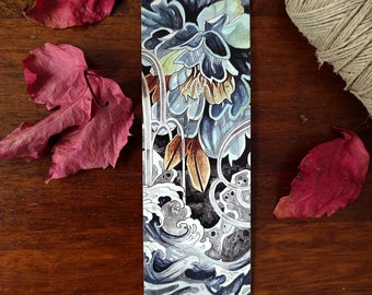 May include: A bookmark featuring a blue and white watercolor illustration of a flower and waves. The flower is in the upper portion of the bookmark and the waves are in the lower portion. The background is black.