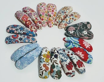 May include: A set of 14 colourful floral patterned hair clips. The clips are all different designs and colours, including blue, green, red, and pink.