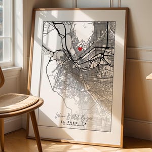 May include: A framed map print of El Paso, TX, with a red heart marking a location. The black and white map is in a wooden frame, leaning against a wall. The text "Where it all began" is at the bottom.