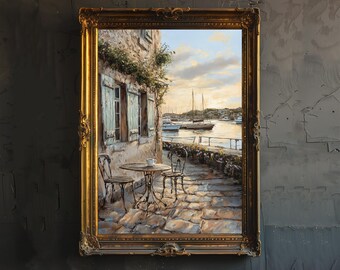 May include: A painting of a quaint, stone building with blue shutters and a small table and chairs on a cobblestone patio. The building is situated on a waterfront with boats in the distance. The sky is a soft blue with clouds.