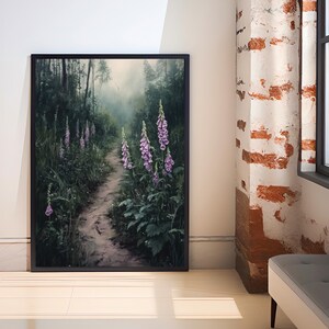 Puede incluir: Impresi&oacute;n art&iacute;stica enmarcada que representa un sereno sendero forestal con flores de dedalera moradas. La obra muestra un camino que se adentra en un bosque brumoso, con vibrantes dedaleras moradas a ambos lados. La impresi&oacute;n est&aacute; en un marco negro.