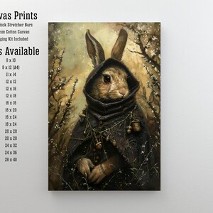 May include: Canvas print of a rabbit wearing a hooded cloak and adorned with acorns. The rabbit has brown fur and is set against a background of a snowy forest with branches and white blossoms.