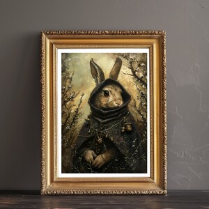 May include: A framed painting of a rabbit wearing a dark hooded cloak and holding a staff. The rabbit is surrounded by a forest scene with a soft, golden light.