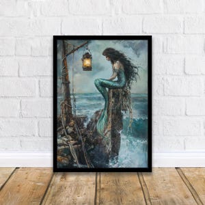Puede incluir: Obra de arte enmarcada que representa a una sirena con largo cabello oscuro y cola turquesa, sentada en una estructura desgastada cerca del mar. Una linterna cuelga arriba, iluminando la escena. La obra est&aacute; ambientada en un fondo de mar tormentoso.